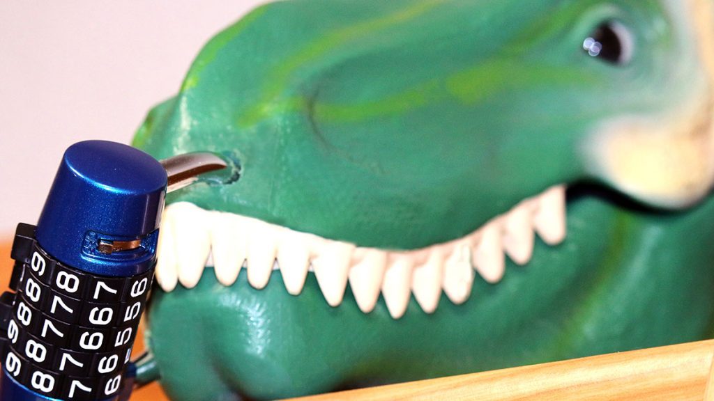 A padlocked box shaped like a dinosaur head.