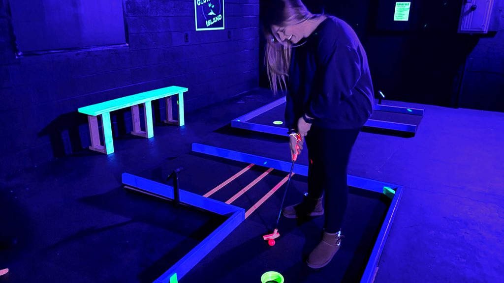 Player putting a mini golf hole.