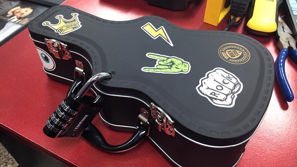 A padlocked box shaped like a guitar.