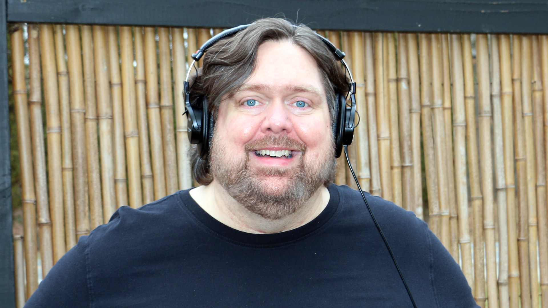 T.M. Kinsley in black, wearing headphones.
